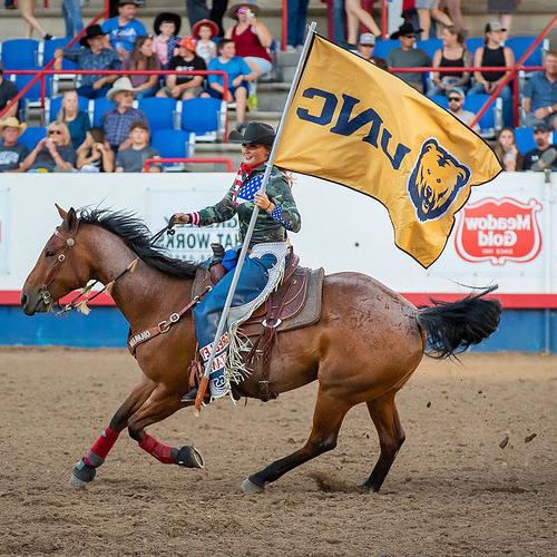 Greeley Stampede rider with UNC flag
